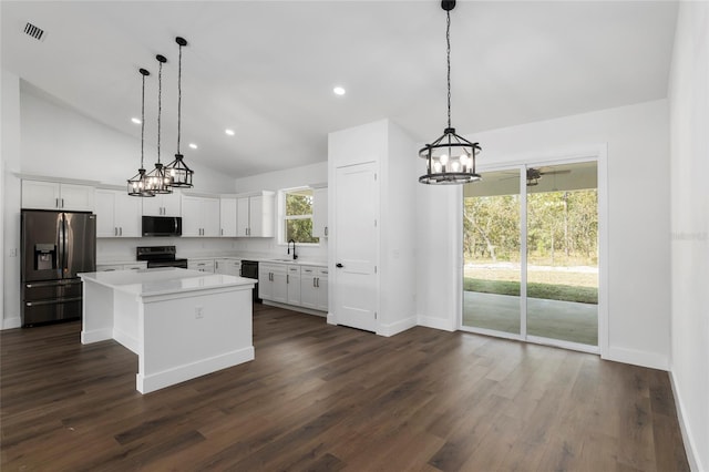 kitchen featuring black appliances, decorative light fixtures, white cabinetry, a kitchen island, and lofted ceiling