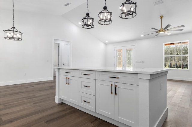 kitchen with ceiling fan with notable chandelier, pendant lighting, dark hardwood / wood-style flooring, and white cabinetry