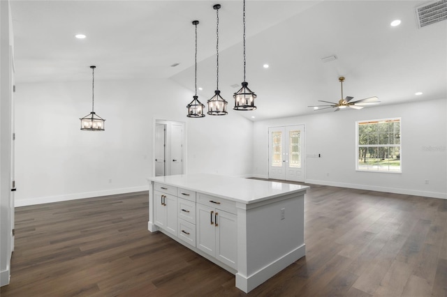 kitchen with white cabinetry, ceiling fan, dark hardwood / wood-style floors, pendant lighting, and vaulted ceiling