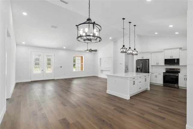 kitchen featuring a center island, hanging light fixtures, stainless steel appliances, white cabinets, and ceiling fan with notable chandelier