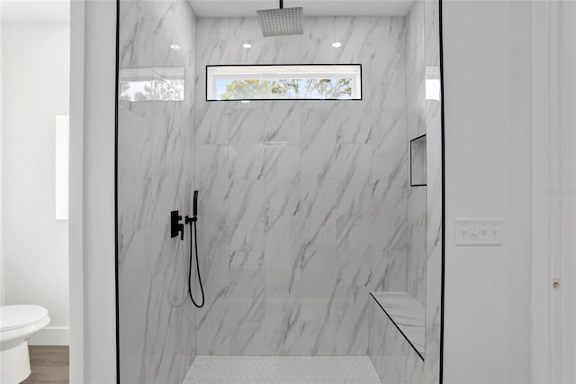 bathroom with toilet, a shower with door, and wood-type flooring