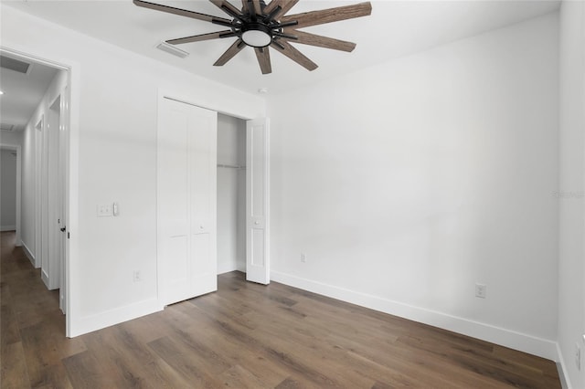 unfurnished bedroom featuring dark hardwood / wood-style floors, ceiling fan, and a closet