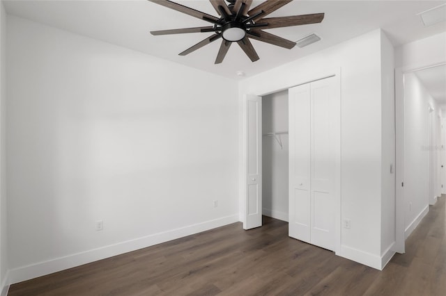 unfurnished bedroom with ceiling fan, dark hardwood / wood-style floors, and a closet