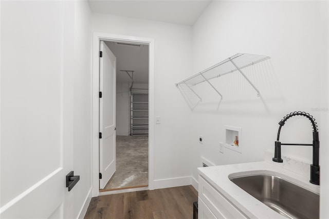 clothes washing area with washer hookup, hookup for an electric dryer, wood-type flooring, and sink