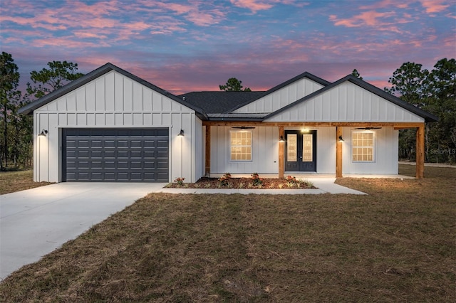 modern inspired farmhouse with french doors, a yard, and a garage