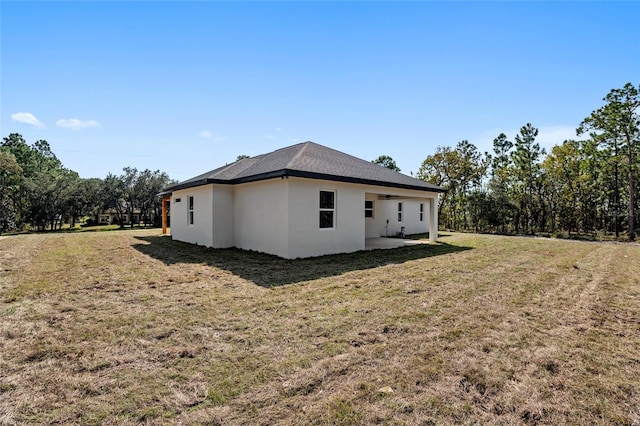 view of property exterior with a lawn and a patio area