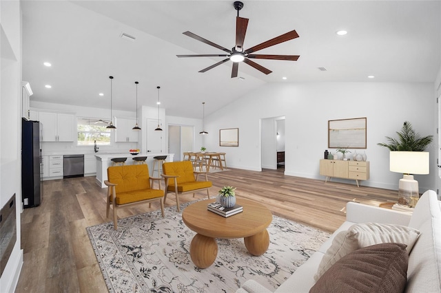 living room featuring hardwood / wood-style floors, ceiling fan, and lofted ceiling