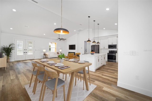 dining area featuring french doors, light hardwood / wood-style flooring, ceiling fan, and lofted ceiling