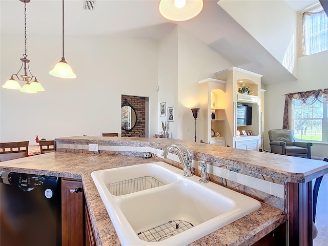 kitchen with black dishwasher, a towering ceiling, sink, decorative light fixtures, and a kitchen island with sink