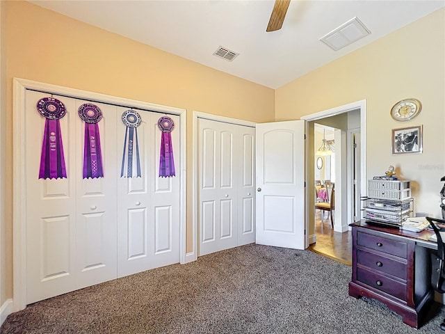 carpeted bedroom featuring ceiling fan and multiple closets