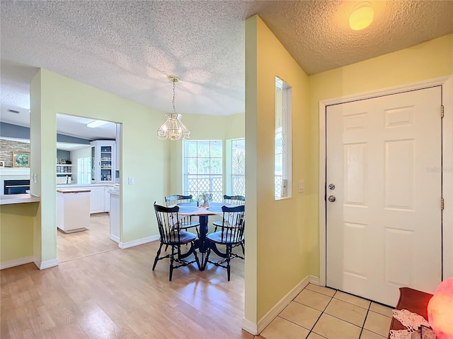 foyer entrance with an inviting chandelier, light hardwood / wood-style flooring, and a textured ceiling