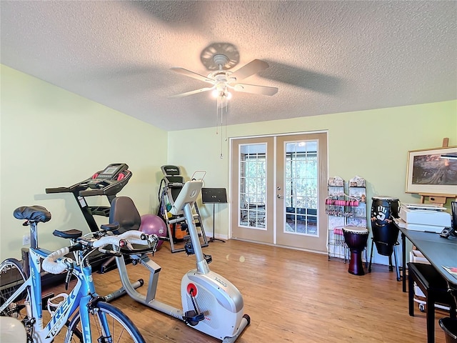 workout area with french doors, light hardwood / wood-style floors, a textured ceiling, and ceiling fan