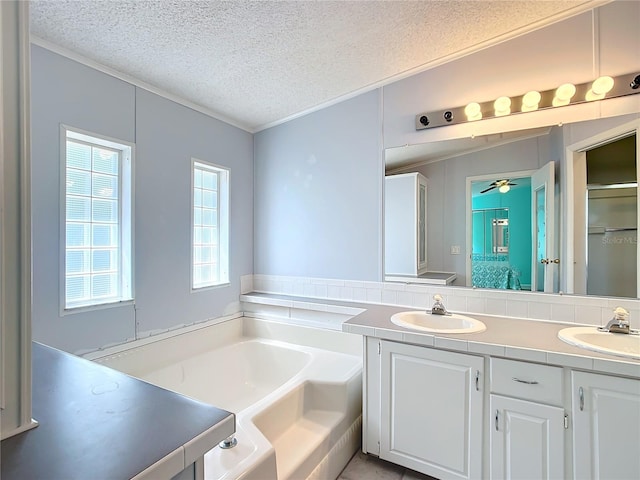 bathroom with vanity, ceiling fan, a textured ceiling, and a washtub