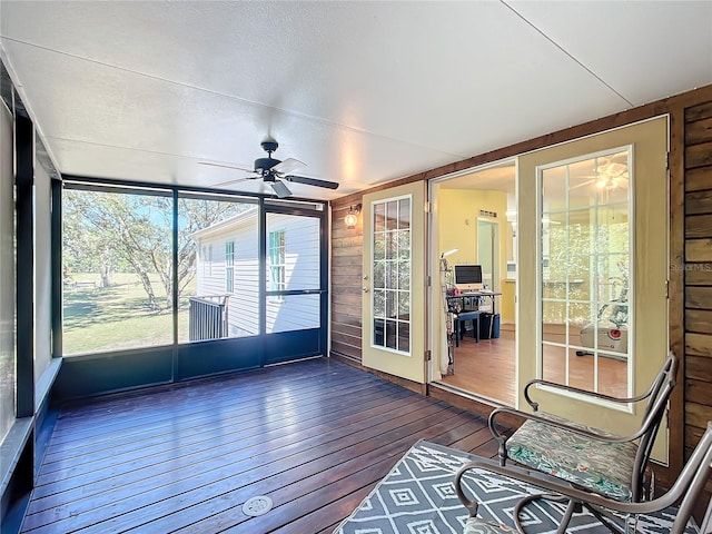 unfurnished sunroom featuring ceiling fan