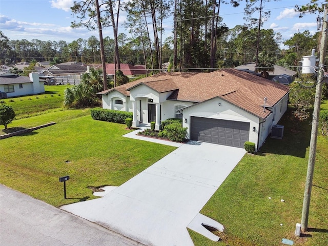 view of front of home featuring cooling unit, a front lawn, and a garage