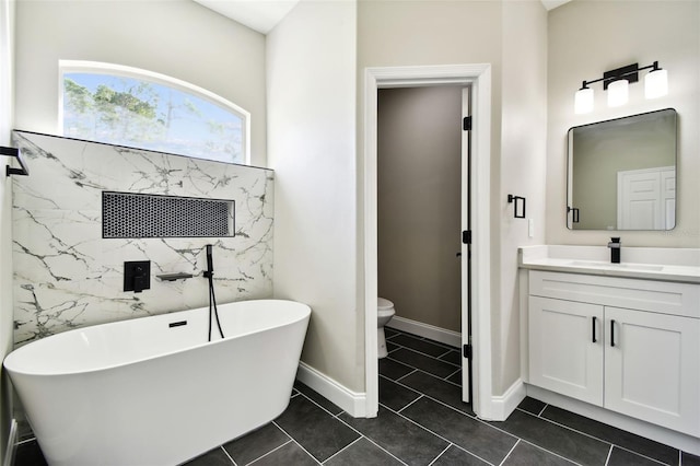 bathroom with vanity, toilet, tile patterned floors, and a bathing tub