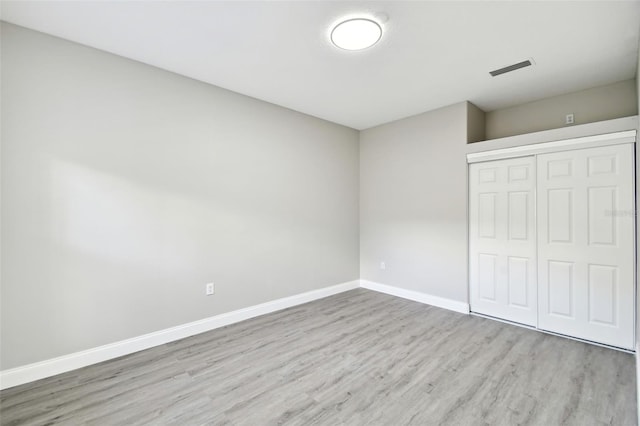 unfurnished bedroom with a closet and light wood-type flooring