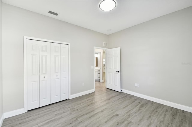 unfurnished bedroom with a closet and light hardwood / wood-style flooring