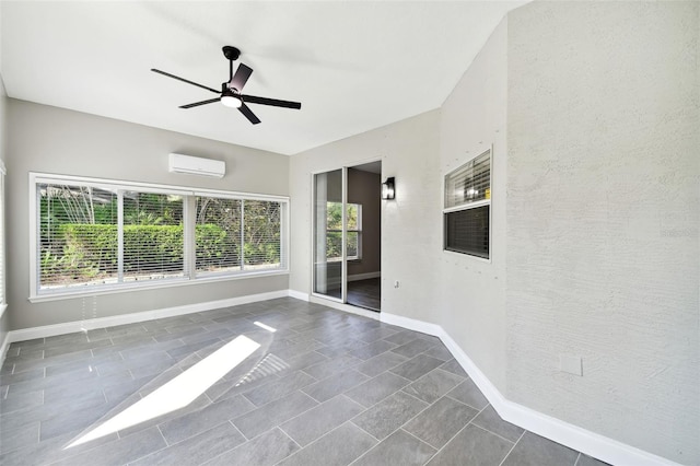 unfurnished sunroom with ceiling fan and an AC wall unit