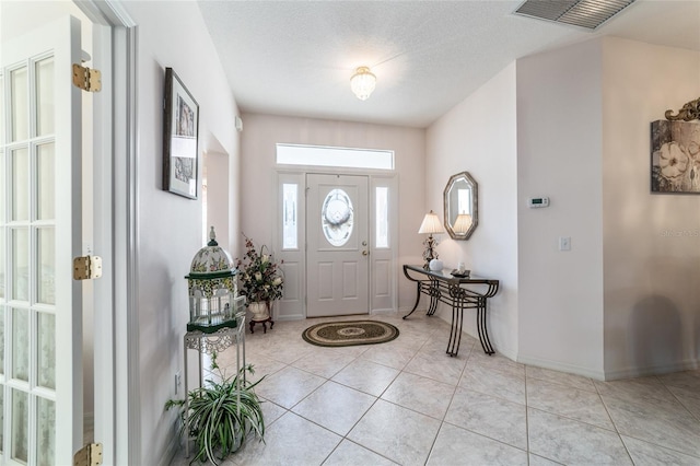 tiled entrance foyer featuring a textured ceiling