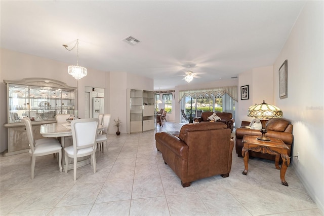 living room featuring light tile patterned flooring and ceiling fan with notable chandelier