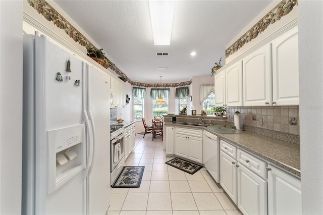 kitchen featuring decorative backsplash, sink, light tile patterned flooring, white cabinets, and white appliances