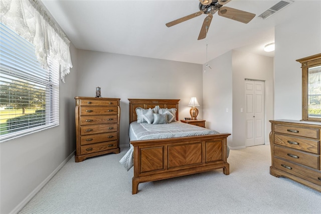 bedroom with a closet, ceiling fan, and light colored carpet