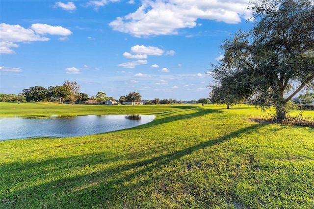 surrounding community with a yard and a water view