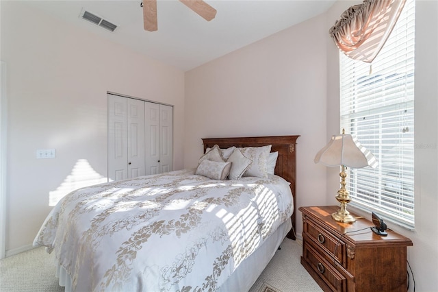 bedroom featuring vaulted ceiling, light carpet, a closet, and ceiling fan