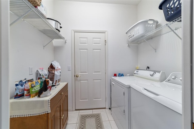 clothes washing area featuring washer and dryer and light tile patterned floors