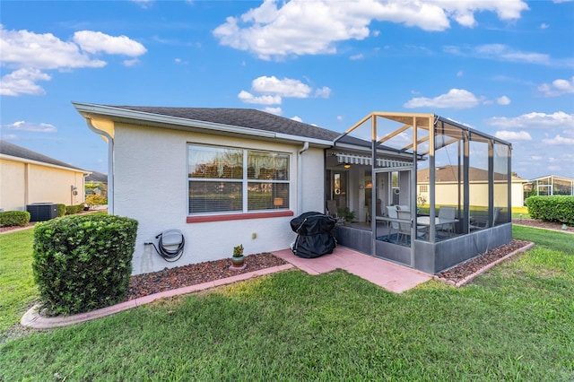 back of property with a patio area, a lanai, and a lawn