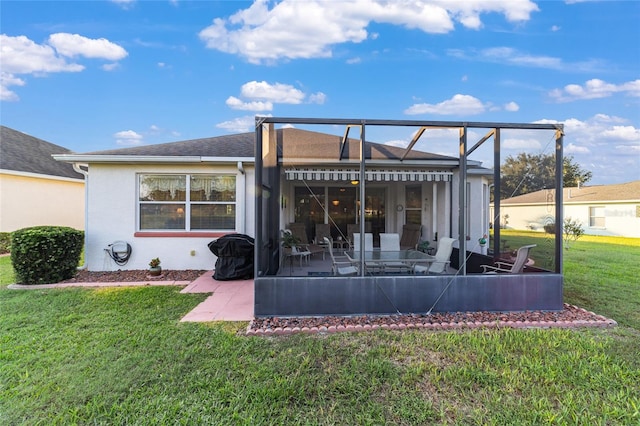 rear view of house featuring a patio area and a lawn