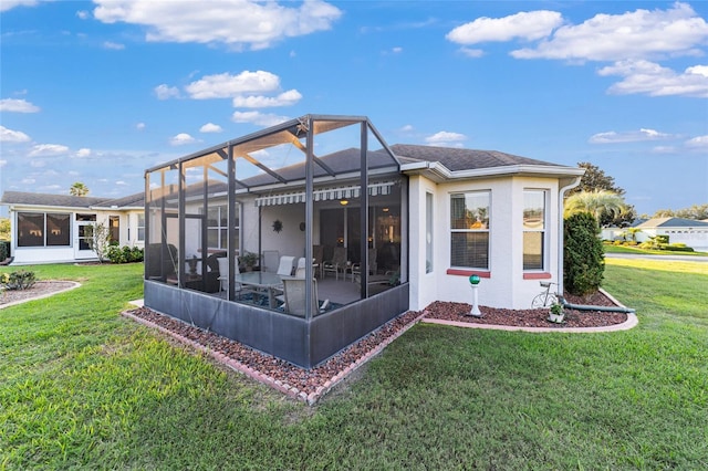 rear view of property featuring glass enclosure, a sunroom, and a lawn