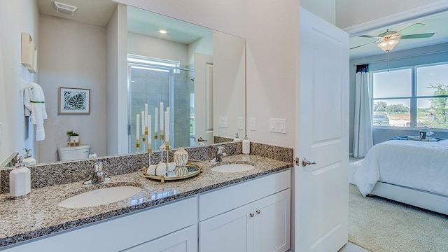 bathroom featuring ceiling fan, vanity, a shower with door, and toilet