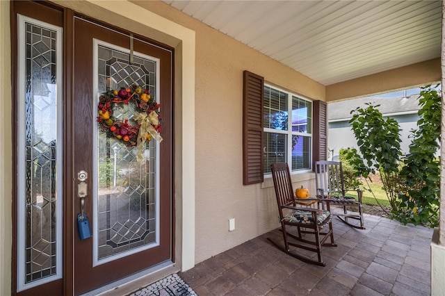 view of exterior entry with a porch