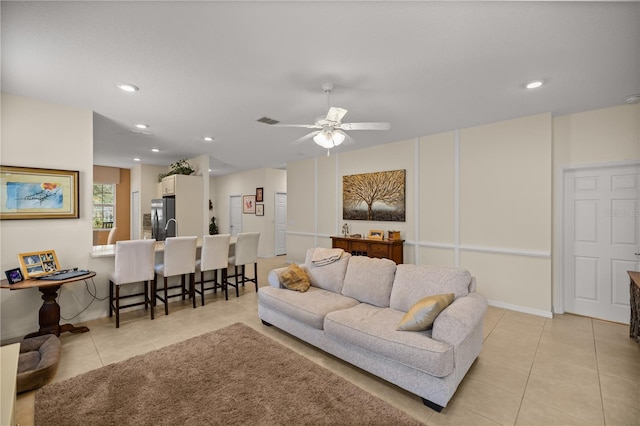 living room featuring light tile patterned floors and ceiling fan