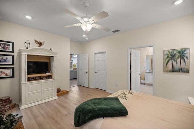 bedroom with ensuite bath, ceiling fan, and light hardwood / wood-style floors