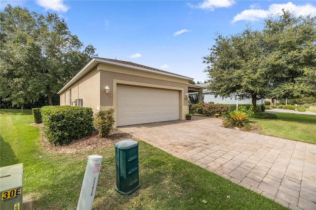 view of side of property featuring a lawn and a garage