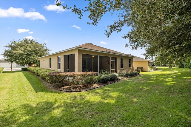 back of house with a lawn and a sunroom