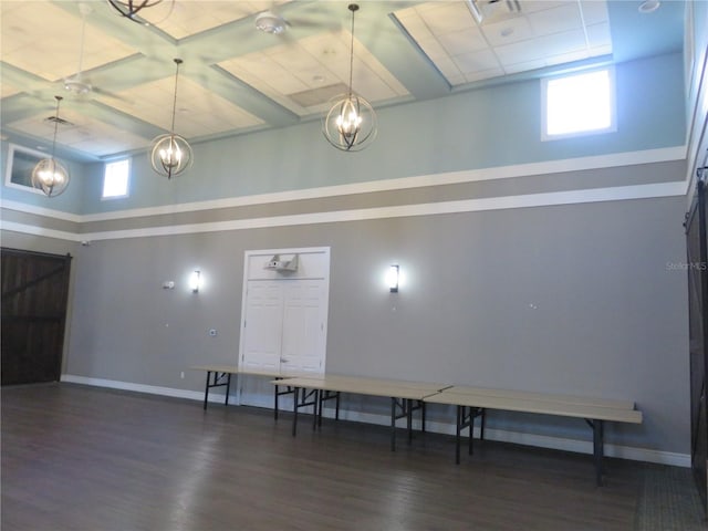 interior space featuring a chandelier, a high ceiling, and dark wood-type flooring