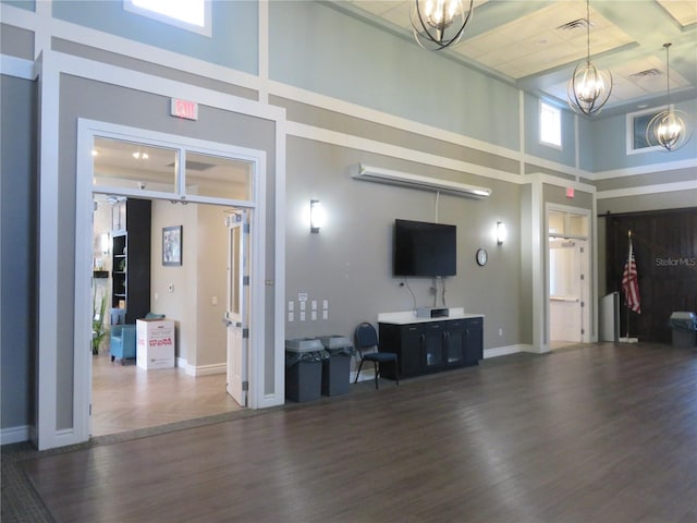 interior space featuring a high ceiling, dark hardwood / wood-style floors, and an inviting chandelier