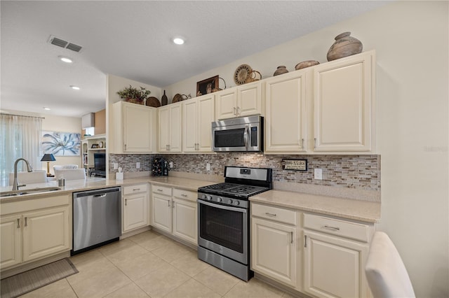 kitchen with tasteful backsplash, sink, light tile patterned floors, and appliances with stainless steel finishes