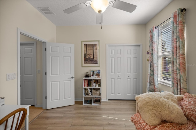 living area featuring a wealth of natural light, light hardwood / wood-style flooring, and ceiling fan