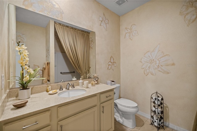 bathroom with tile patterned flooring, vanity, and toilet