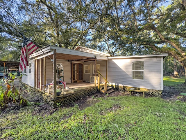 back of house featuring a deck and a lawn