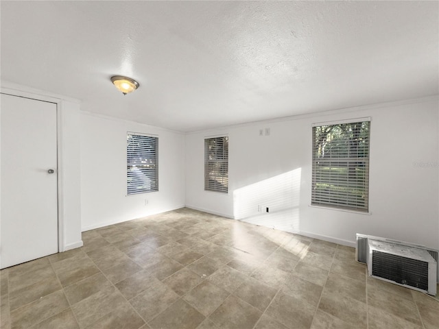 unfurnished room featuring ornamental molding, a textured ceiling, and heating unit