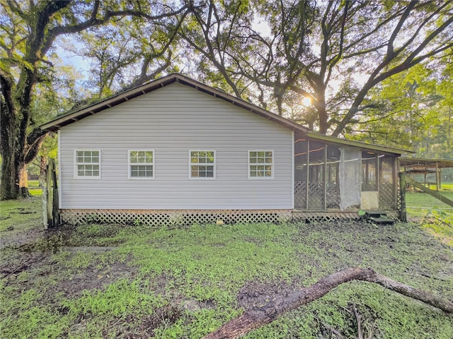 view of side of home with a yard and a sunroom