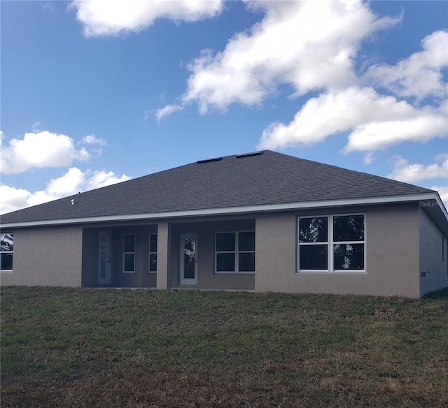 rear view of property featuring a yard