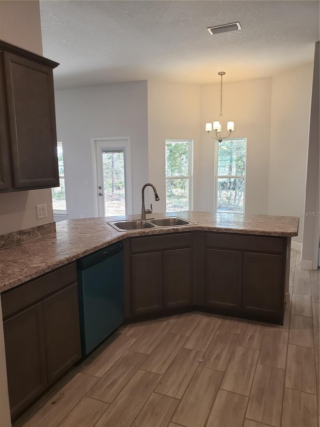 kitchen with black dishwasher, kitchen peninsula, sink, a notable chandelier, and light hardwood / wood-style floors