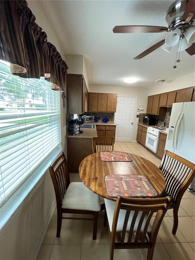 tiled dining space with ceiling fan